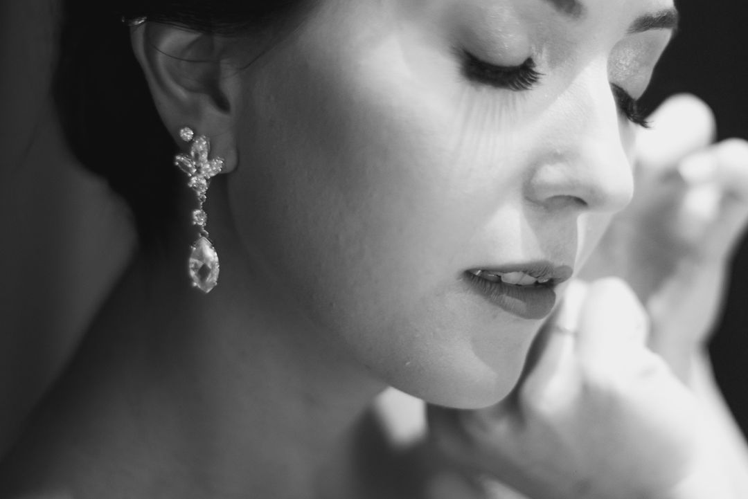 Noiva de perfil em preto e branco, se arrumando para a cerimônia