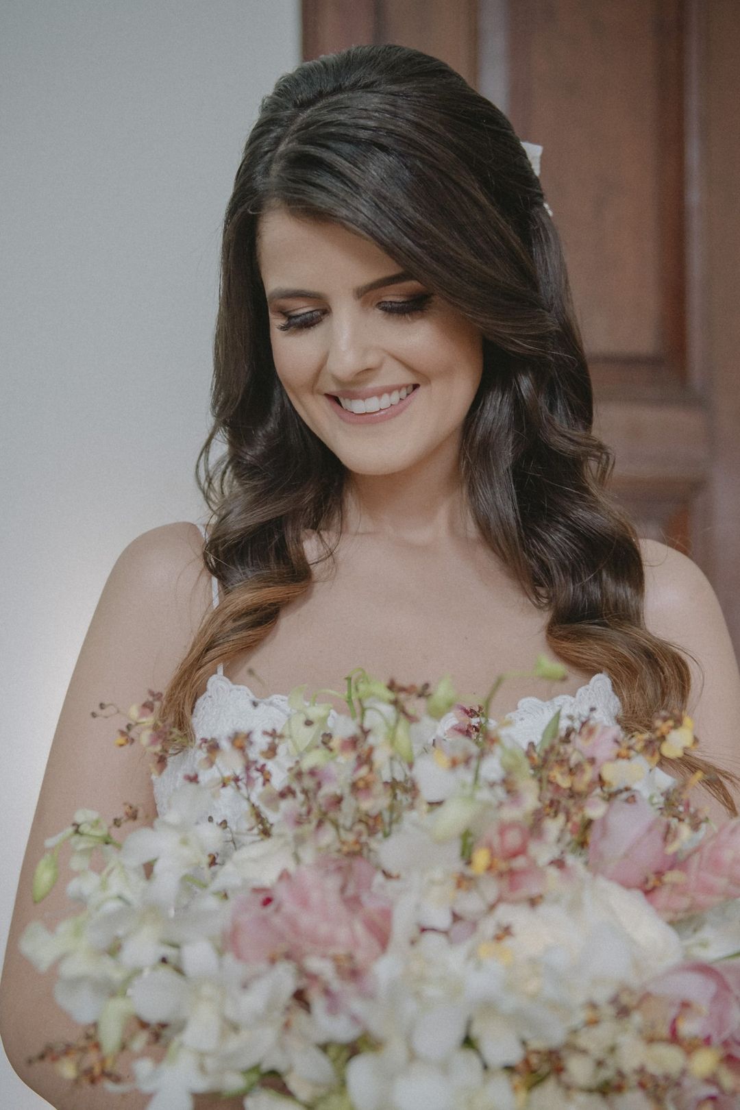Noiva sorrindo com um buquê de flores claras