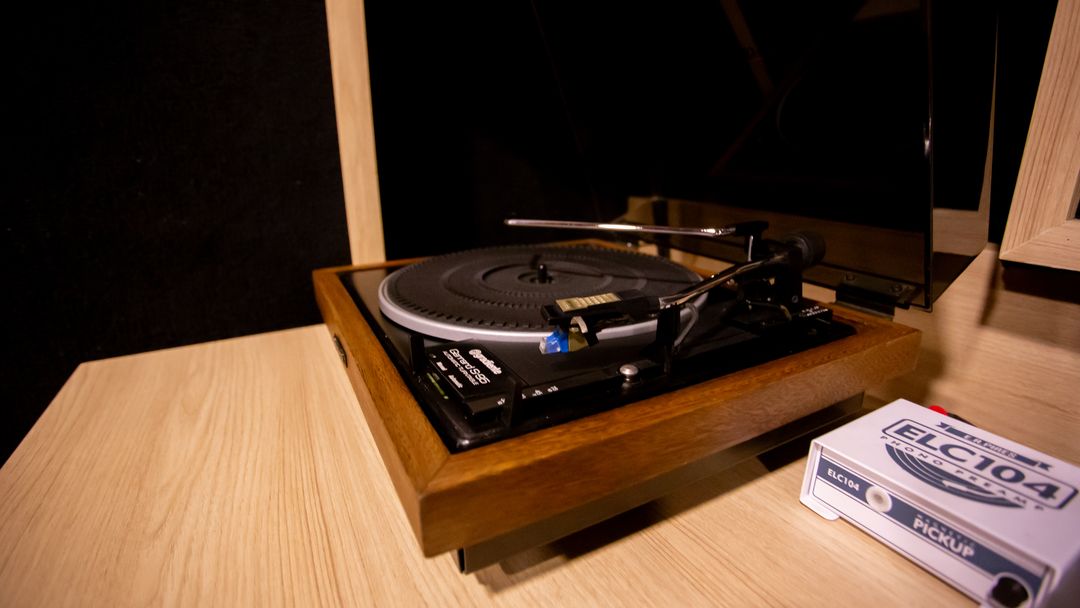 Detalhe de uma toca-discos sobre mesa de madeira no Estúdio A